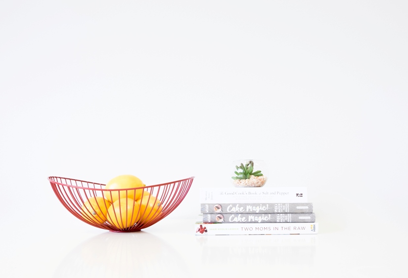 red fruit bowl and stack of cook books